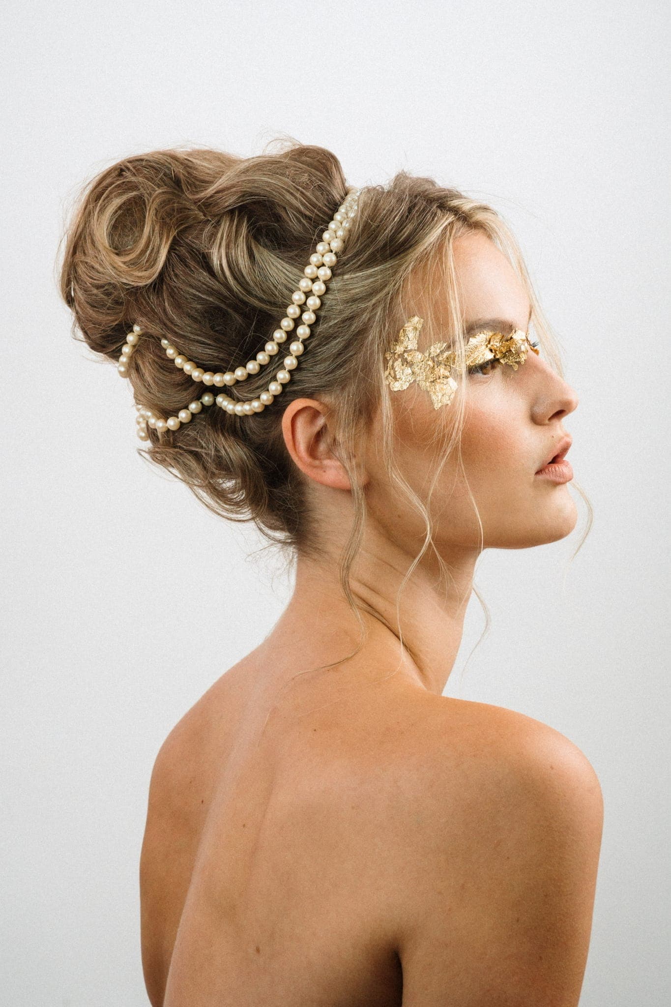 Elaborate bridal updo woven with pearl strands