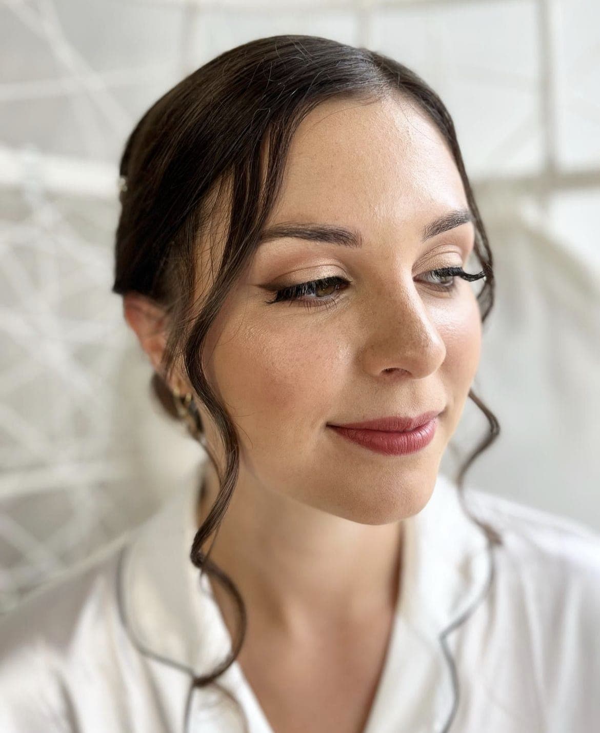 Close portrait of a bride with soft face-framing curls, looking down