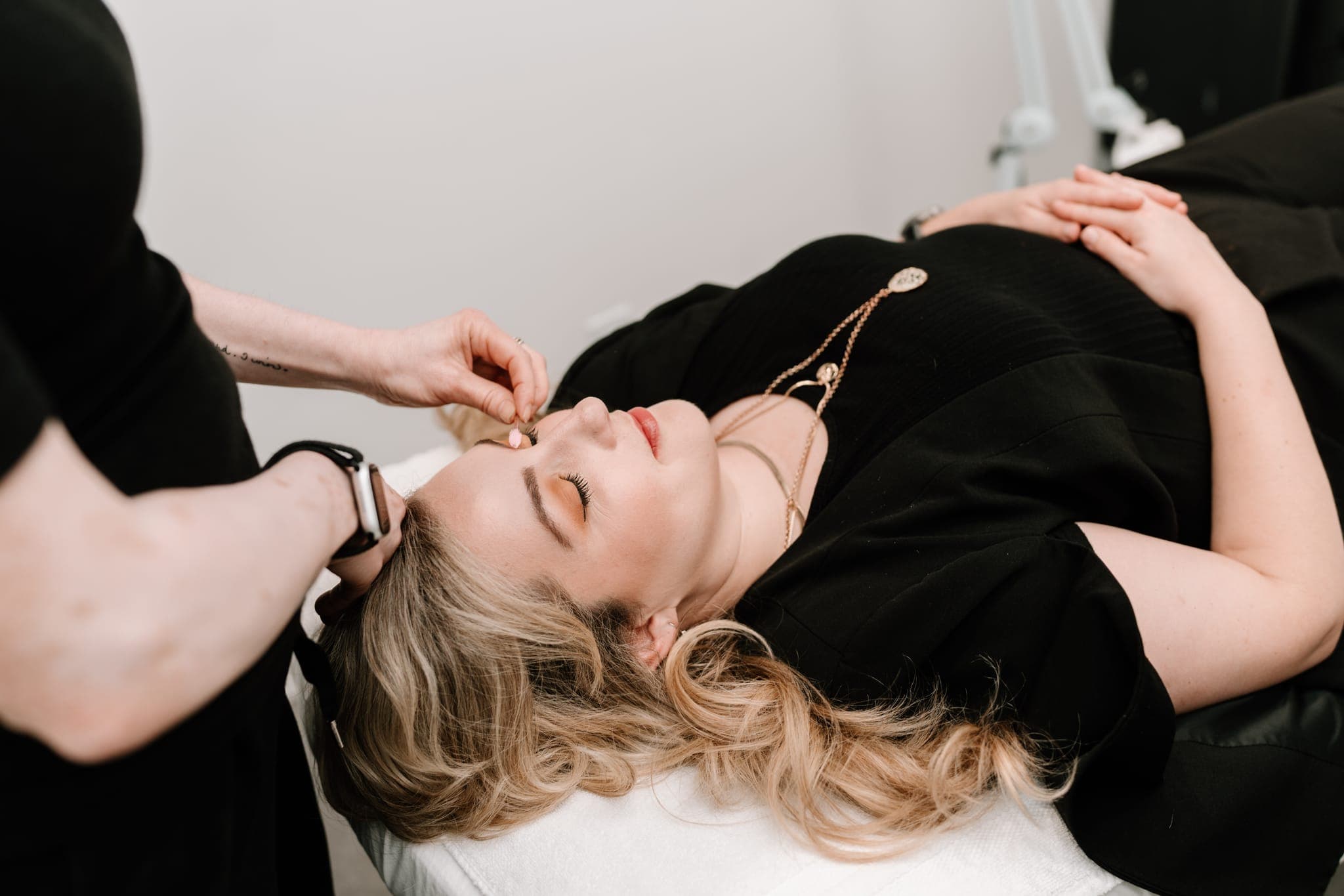 Brow specialist working on a reclining client at Lustre of Pearl