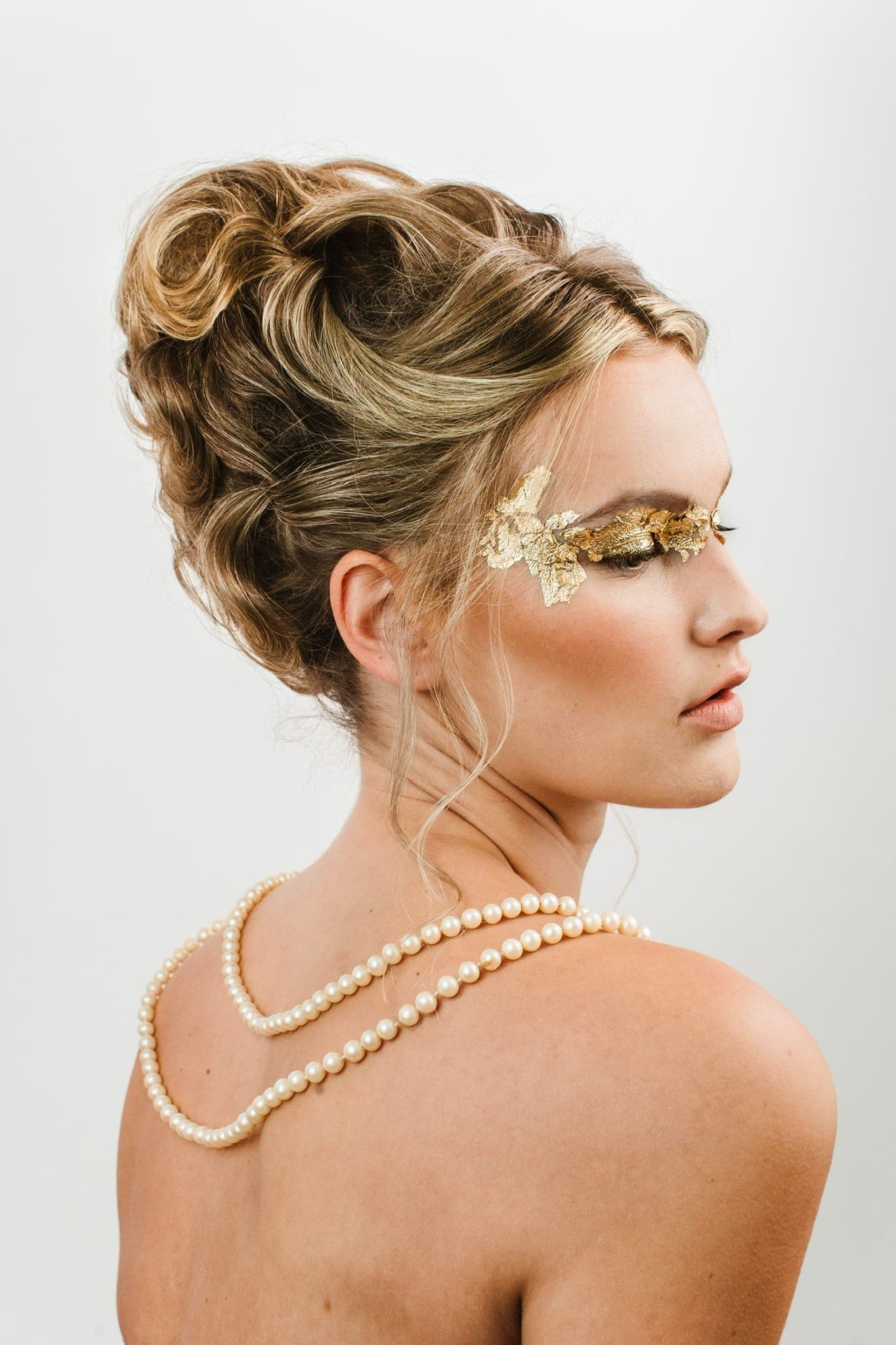 Back view of a voluminous styled updo with pearl details