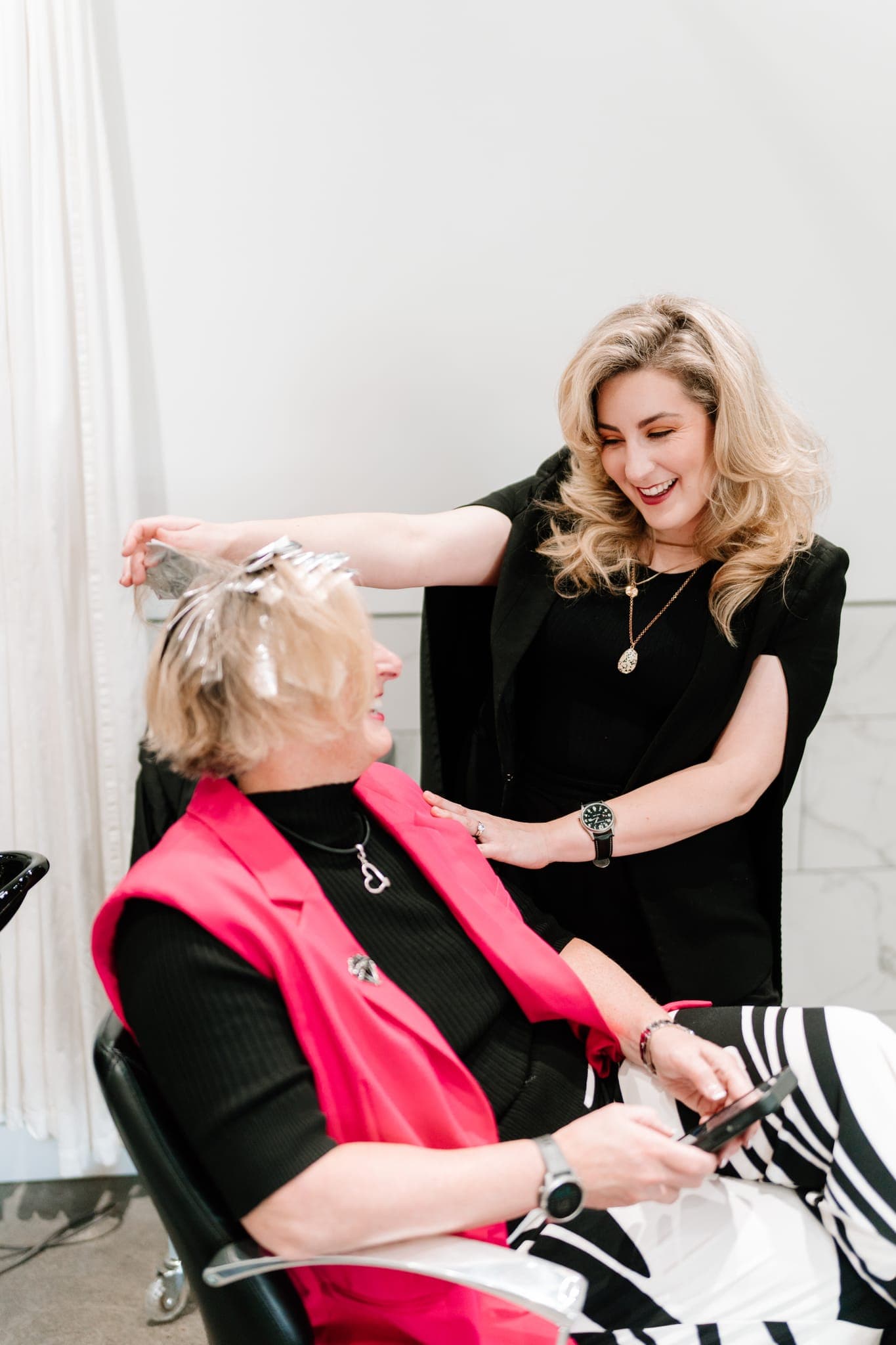 Lustre of Pearl stylist applying colour to a smiling client