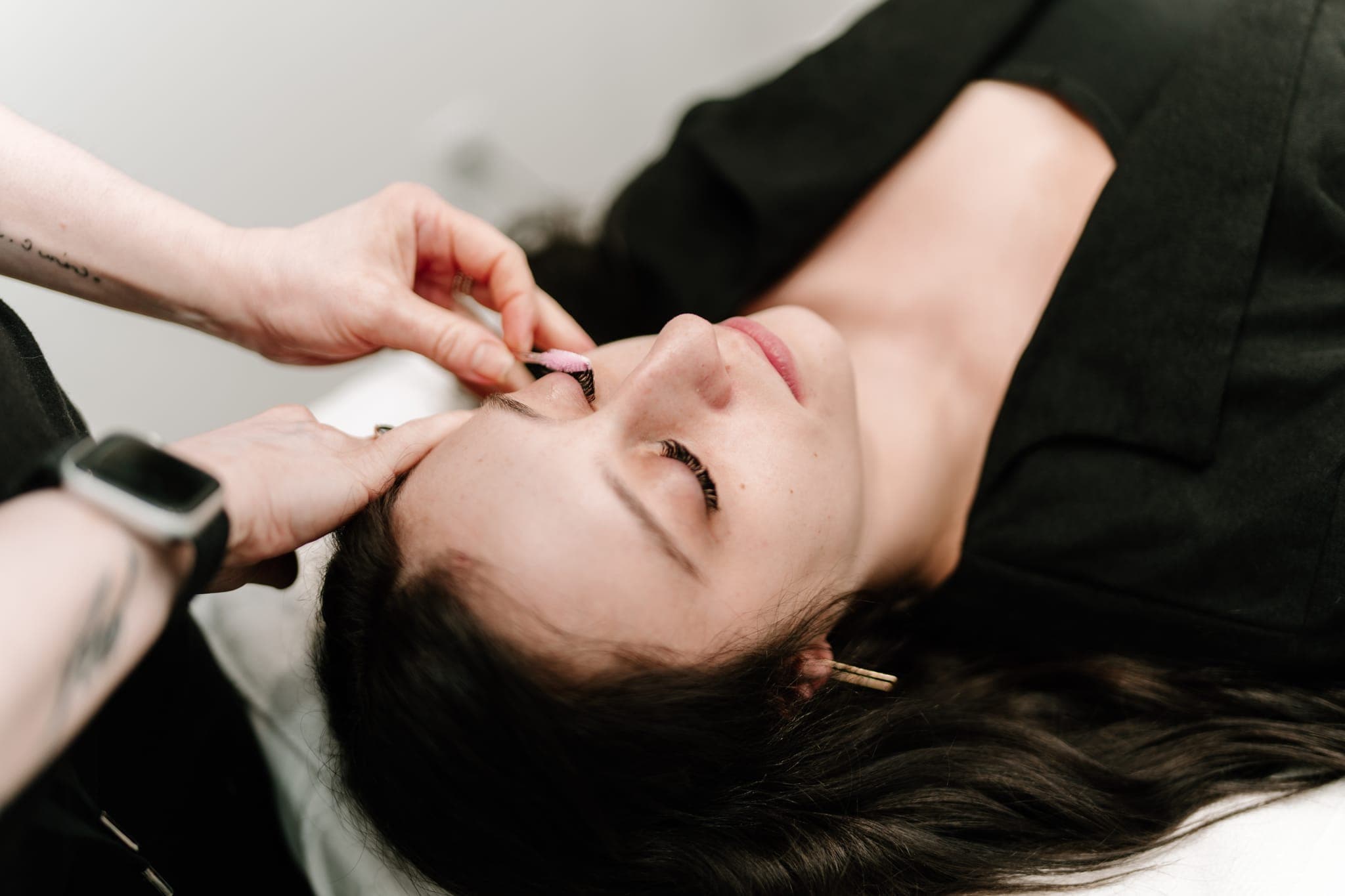 Lash artist isolating lashes during a treatment at Lustre of Pearl