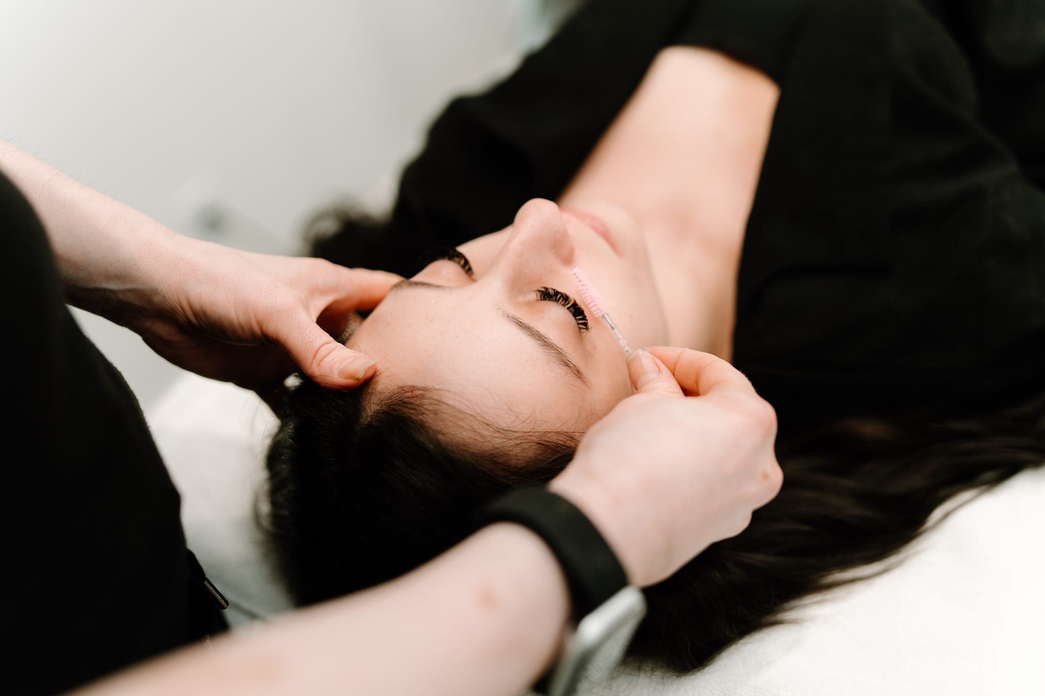 Close-up of a lash treatment being applied to a reclining client